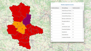 Abgebildet ist eine Karte des Landes Sachsen-Anhalt, in der die einzelnen Landkreise unterschiedlich farblich markiert sind. Daneben ist eine Tabelle zu sehen, in der die Landkreis und die zugehörige Waldbrandwarnstufe aufgelistet sind.