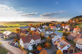 Drohnenaufnahme eines Dorfes in warmen Farben